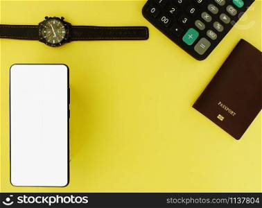 The white screen smartphone with calculator and watch on a yellow background