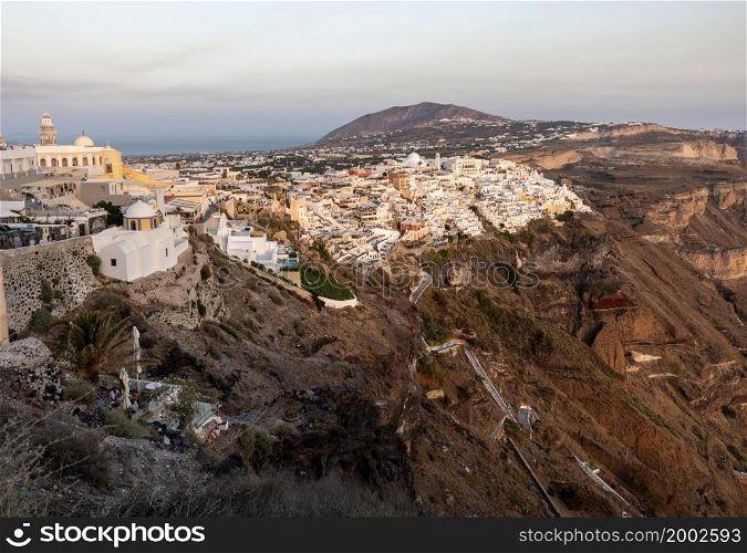 The whitewashed town of Fira in warm rays of sunset on Santorini island, Cyclades, Greece. The whitewashed town of Fira in warm rays of sunset on Santorini island