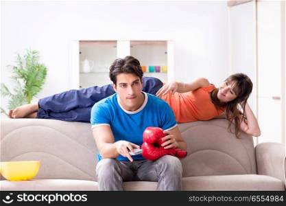The wife unhappy that husband is watching boxing. Wife unhappy that husband is watching boxing. The wife unhappy that husband is watching boxing