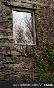 The window in the gable end of what was the main slate mill at the Dorothea Slate Quarry, This is in Nantlle, Gwynedd, Wales, United Kingdom. This frame will not last many more winters. Neither will the gable end.