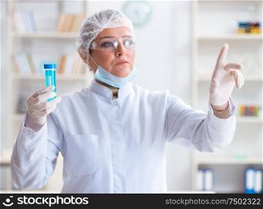 The woman chemist pressing virtual button in lab. Woman chemist pressing virtual button in lab