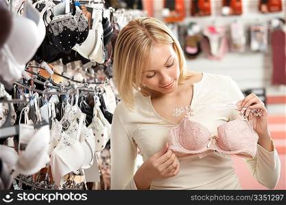 The woman considers a brassiere in shop