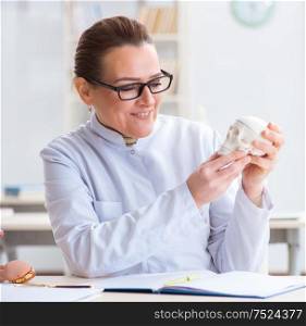 The woman doctor studying human skeleton. Woman doctor studying human skeleton