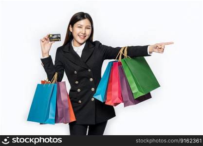 The woman dressed in black went shopping, carrying credit cards and lots of bags.