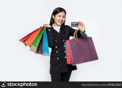 The woman dressed in black went shopping, carrying credit cards and lots of bags.