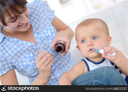 the woman gives to the sick baby medicine