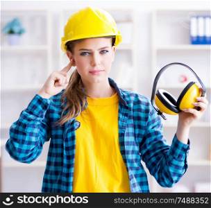 The woman in workshop with noise cancelling headphones. Woman in workshop with noise cancelling headphones
