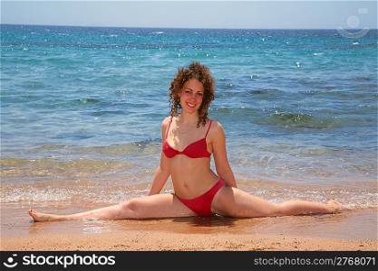 The woman is engaged in gymnastics at the sea