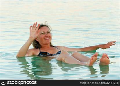 The woman lies on the water from the Dead Sea