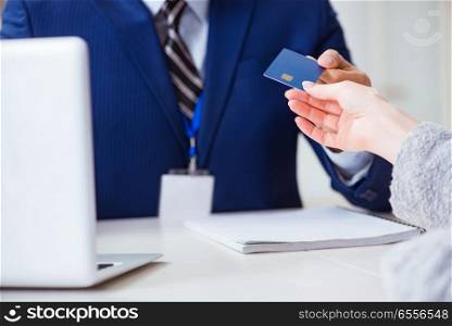 The woman makes payment with credit card . Woman makes payment with credit card