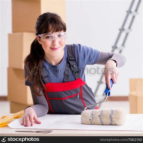 The woman preparing for wallpaper work. Woman preparing for wallpaper work