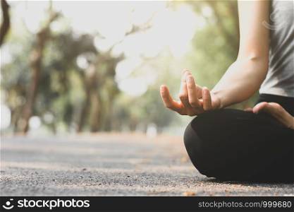 The woman's right hand is meditating at the park.
