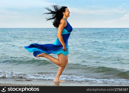 The woman runs on sea coast. A picturesque landscape