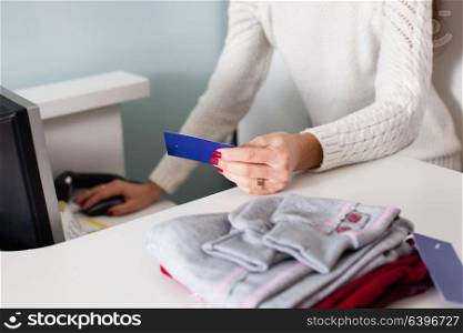 The woman-seller checks the prices for barcode. Seller conscientiously works