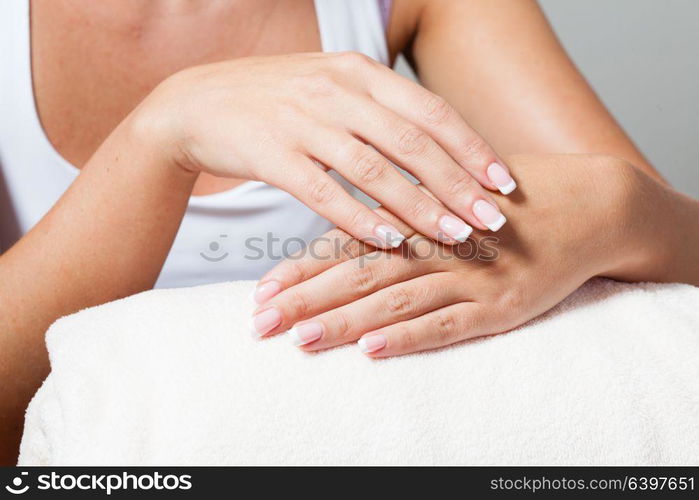 The woman shows a beautiful French manicure putting hand on one another. Unsurpassed French manicure