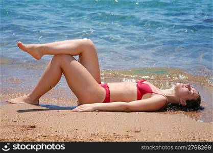 The woman sunbathes at the sea