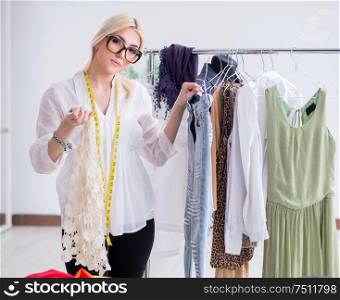 The woman tailor working on new dress designs. Woman tailor working on new dress designs