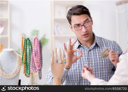The woman visiting jeweler for jewelery evaluation. Woman visiting jeweler for jewelery evaluation