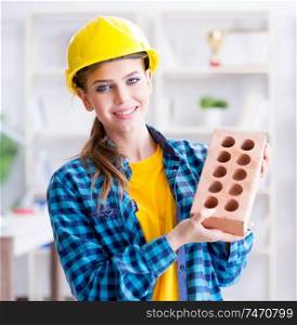 The woman with brick in construction concept. Woman with brick in construction concept