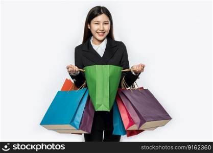 The woman wore black clothing, along with many bags, to go shopπng.