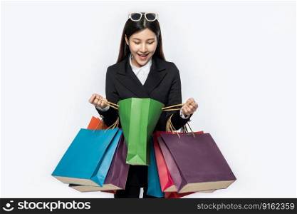 The woman wore black clothing, along with many bags, to go shopping.