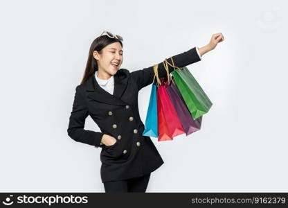 The woman wore black clothing, along with many bags, to go shopping.