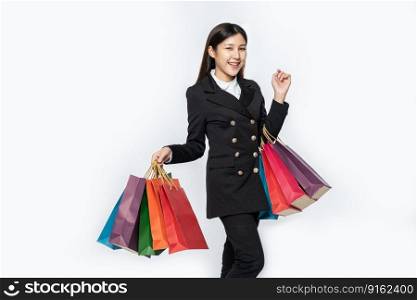 The woman wore black clothing, along with many bags, to go shopping.
