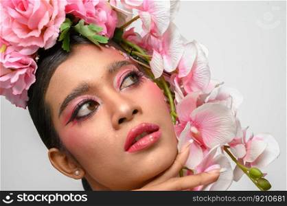 The woman wore pink makeup and beautifully decorated the flowers. Isolated on white background