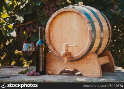 The wooden barrel with wine on a table outdoor. Winery culture. The wooden barrel