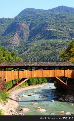 The Wooden Bridge Over the Adige River at the Foot of the Italian Alps