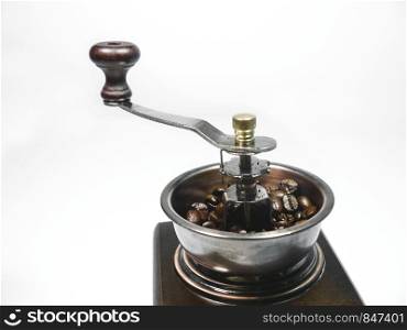 The wooden coffee grinder with coffee beans on white background. Close-up