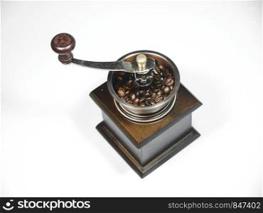 The wooden coffee grinder with coffee beans on white background. The view from above