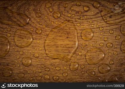The wooden texture of an oak plank sprinkled with rain drops.