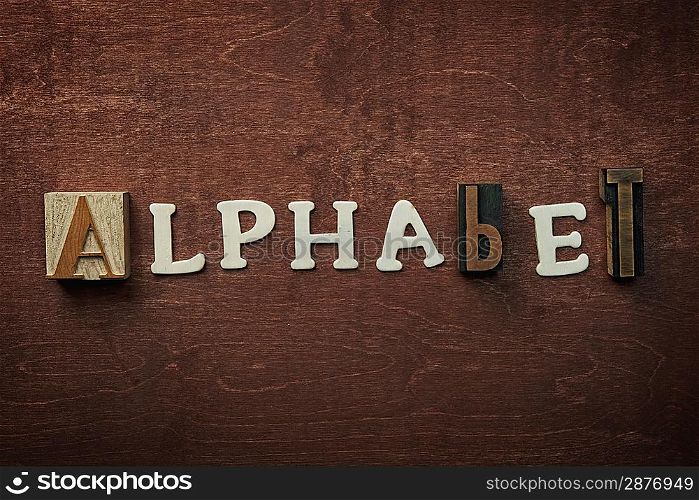 The word alphabet written on wooden background