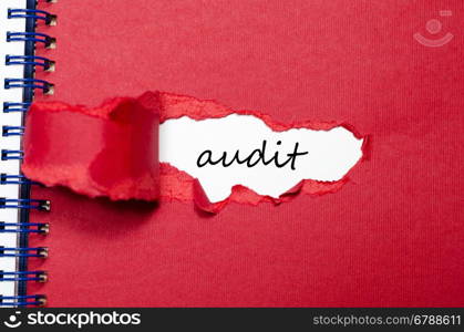 The word audit appearing behind torn paper