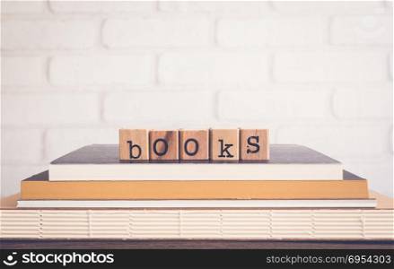 The word Books, alphabet on wooden cubes on top of books. Background copy space, vintage minimal style. Knowledge sources and education concepts for library club, school training courses or institute.