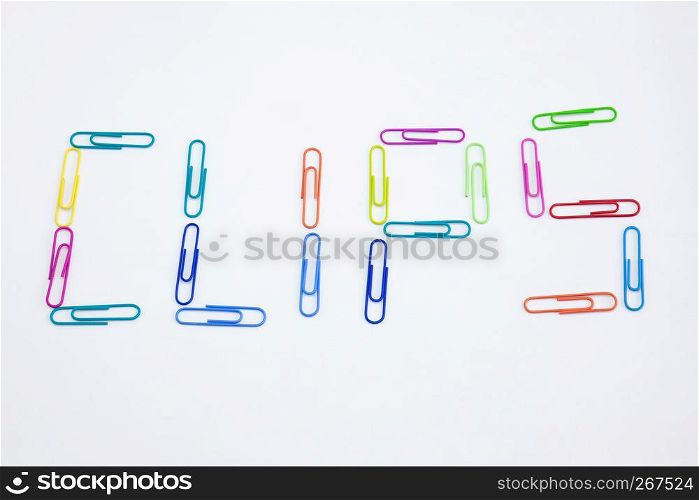 The word CLIPS made from colorful paperclips, Top view closeup.