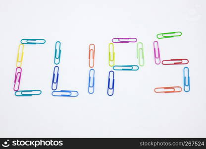 The word CLIPS made from colorful paperclips, Top view closeup.