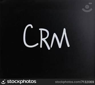 "The word "CRM" handwritten with white chalk on a blackboard"