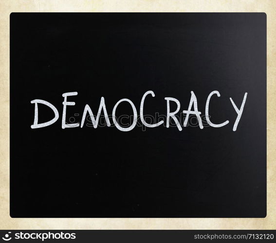 "The word "Democracy" handwritten with white chalk on a blackboard"