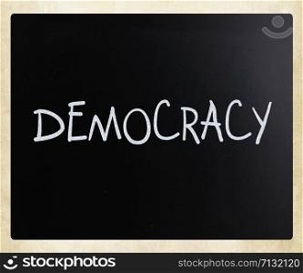 "The word "Democracy" handwritten with white chalk on a blackboard"