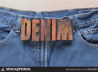 the word denim in wood type on an old pair of jeans