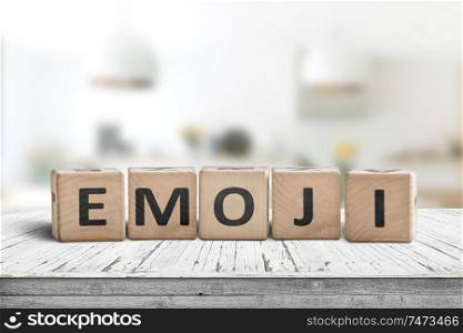 The word emoji on a wooden sign in a bright room on a white desk