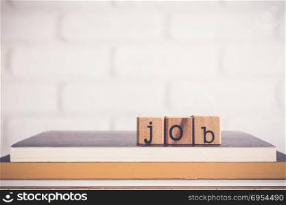 The word Job, alphabet on wooden cubes on top of books. Background copy space, minimal. Job application process, creating safe job procedures and work practices for employee and human resources.