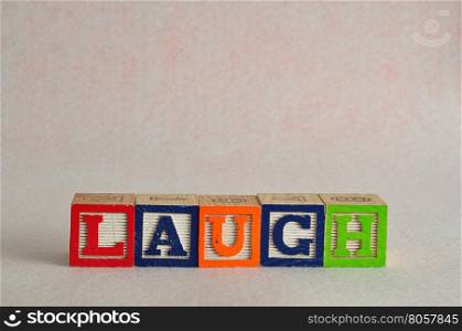 The word laugh spelled with colorful blocks isolated on a white background