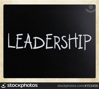 "The word "Leadership" handwritten with white chalk on a blackboard"