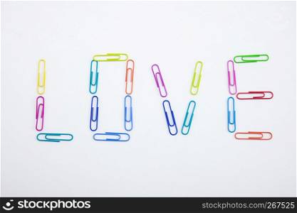 The word LOVE made from colorful paperclips, Top view closeup.