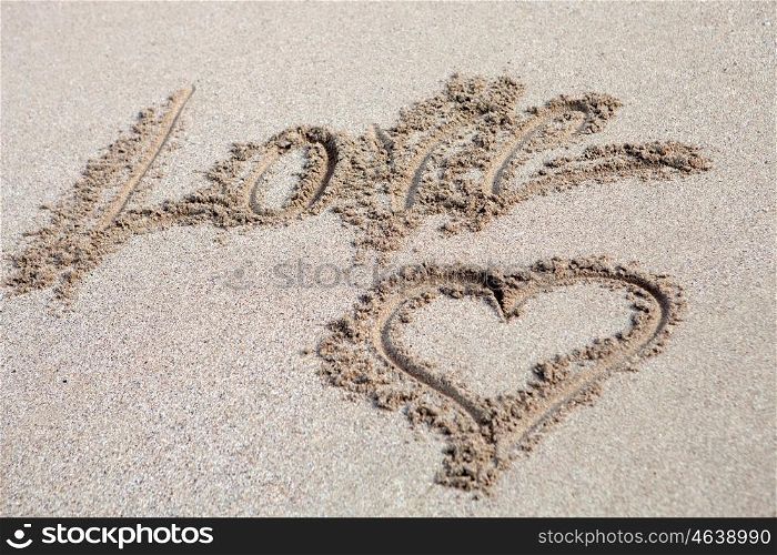 The word Love written on the sand with a hearth drawing