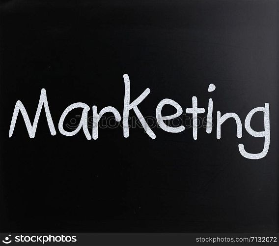 "The word "Marketing" handwritten with white chalk on a blackboard"