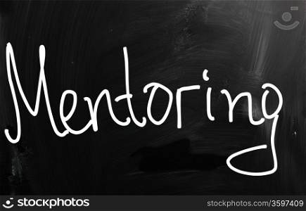 "The word "Mentoring" handwritten with white chalk on a blackboard"